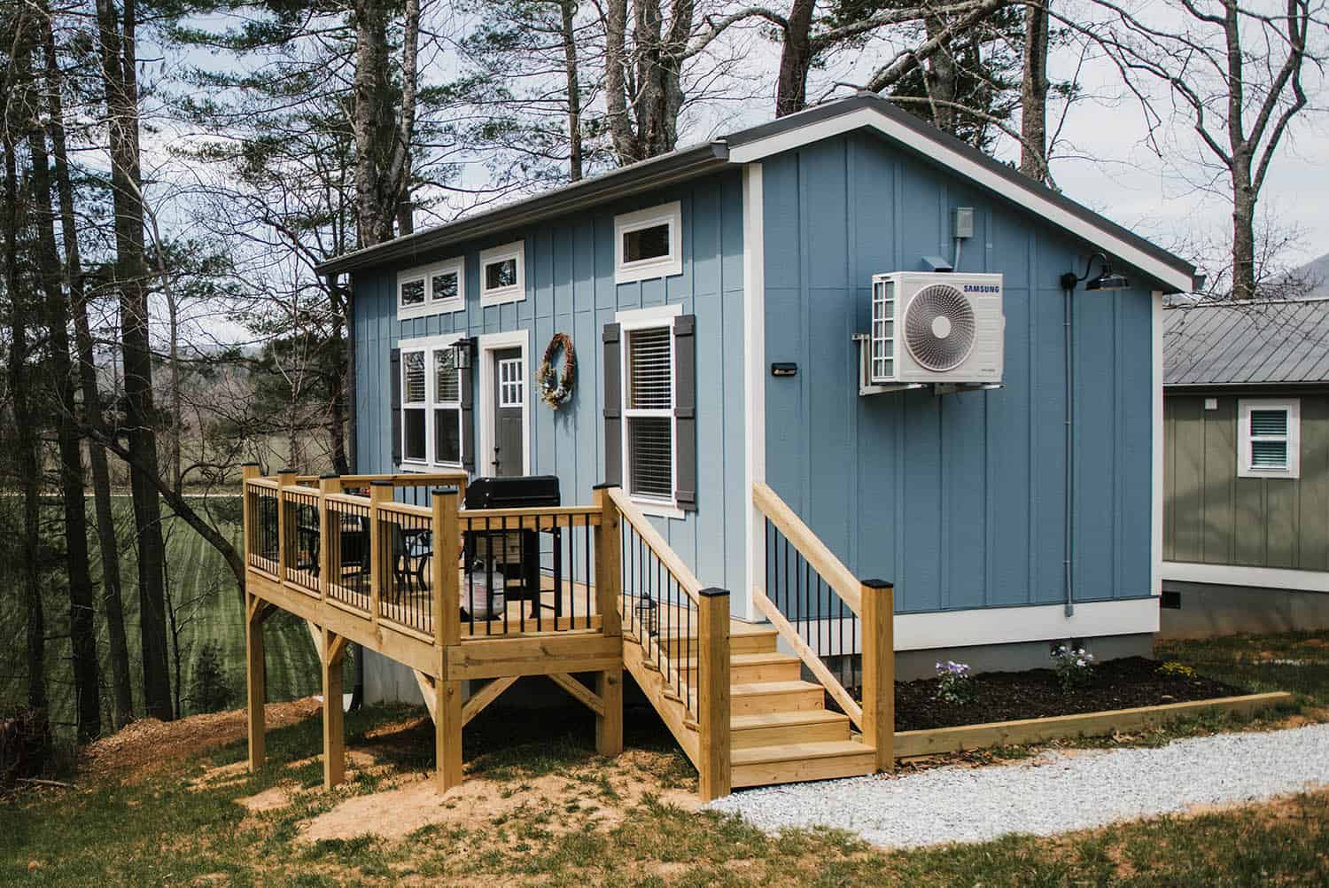 blue siding exterior on modular tiny home with wood decking
