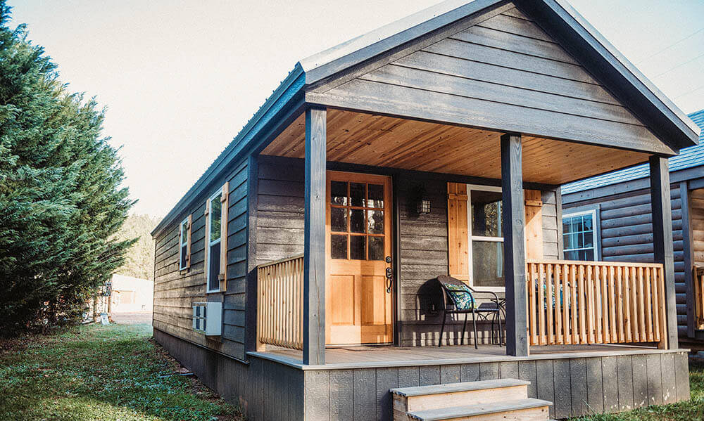 black siding and wood accents on covered porch on modular log cabin