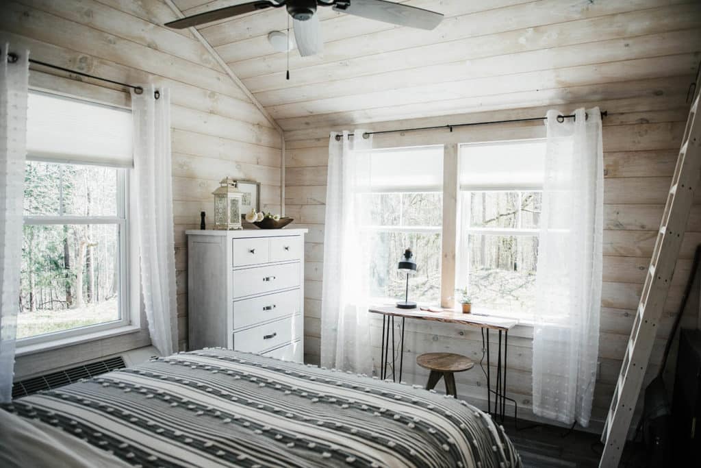 white wood walls in bedroom with cottage style prefab tiny home