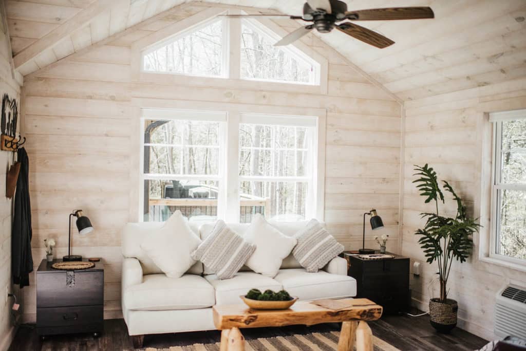 white cottage style modern living space with windows in modular log cabin