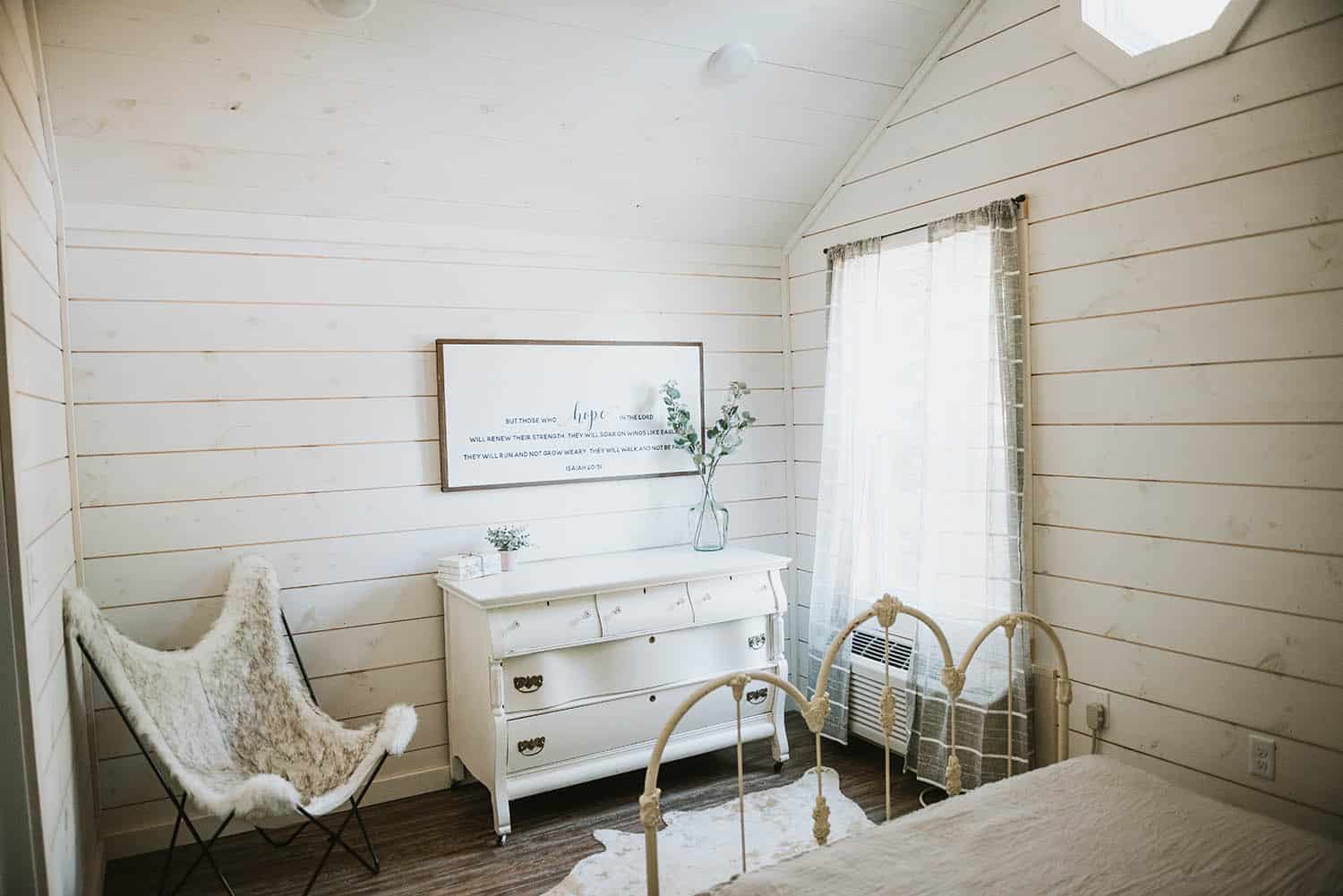 white wooden interior walls in cottage style bedroom in prefab tiny home