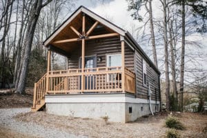 wood siding on modular log cabin with wood accents on covered porch