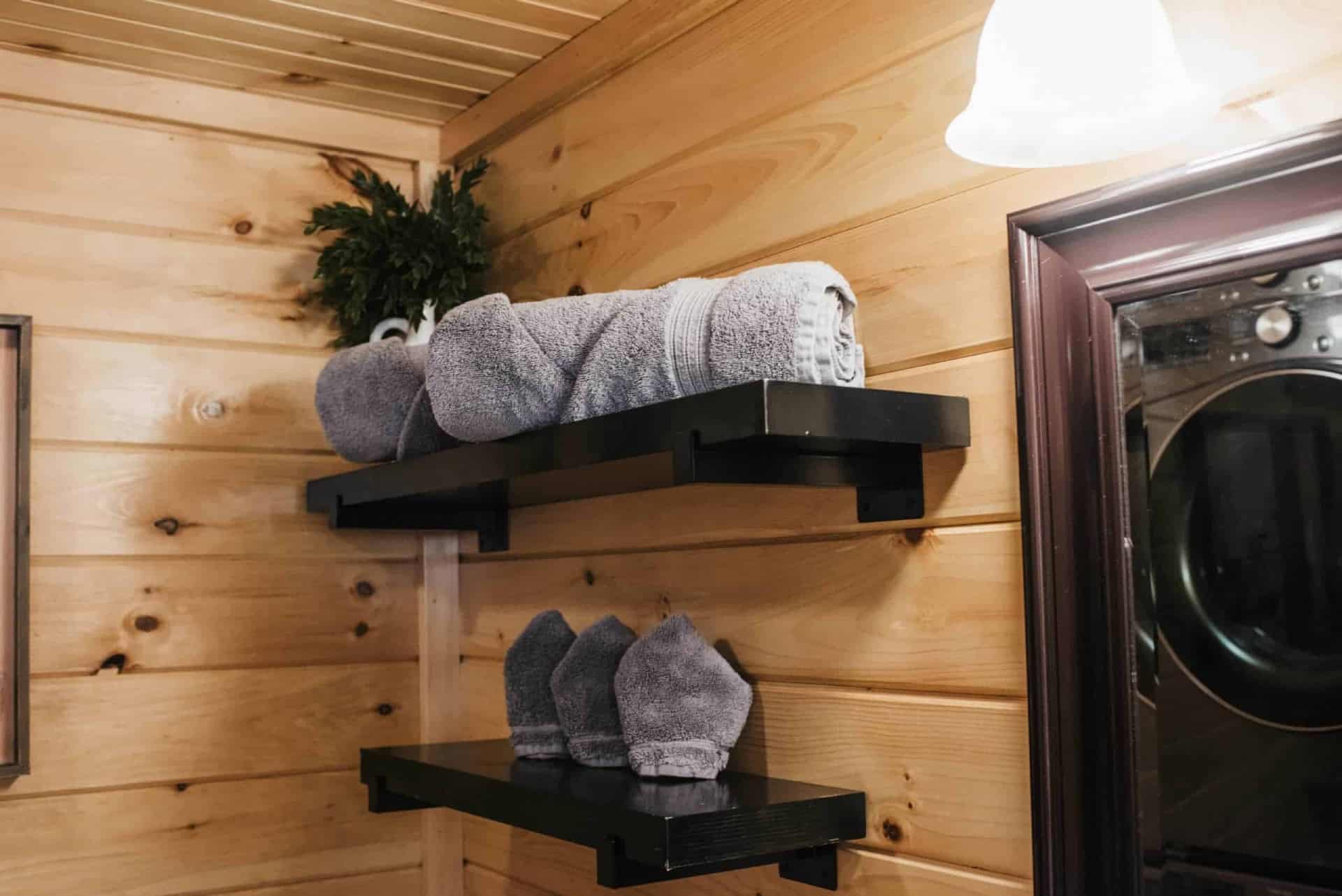 black shelving on wooden interior in laundry area of prefab log cabin