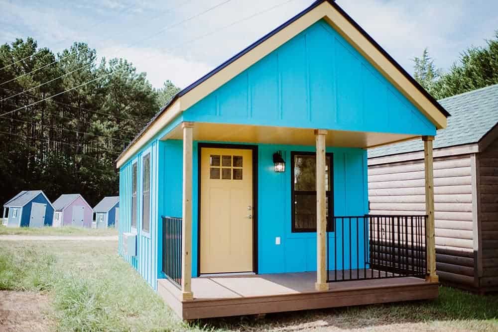 blue and yellow prefab tiny home with covered porch
