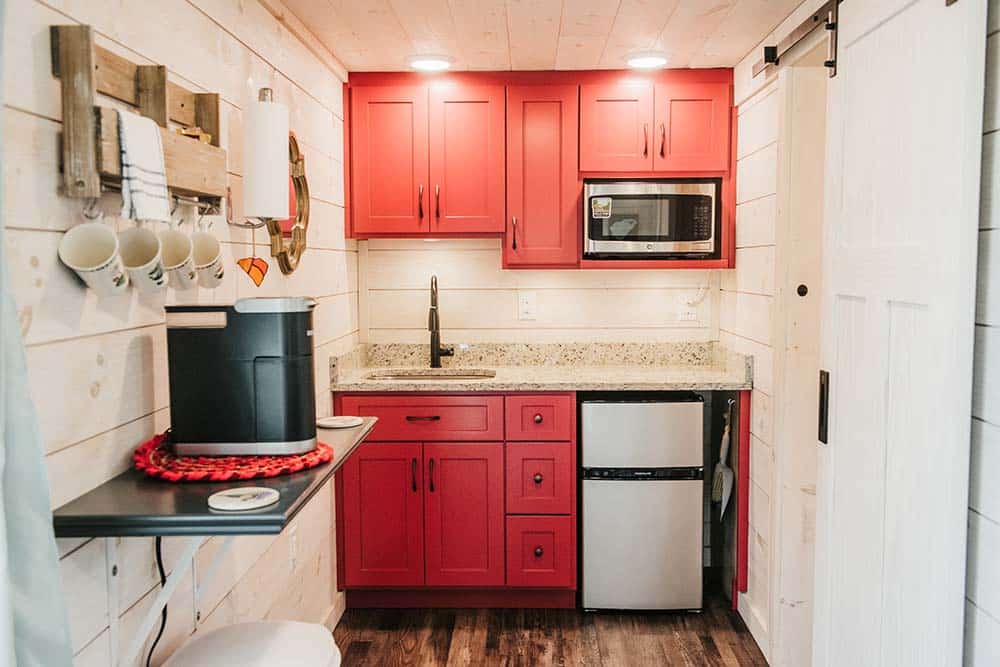 red cabinets in white interior kitchen in modular cabin