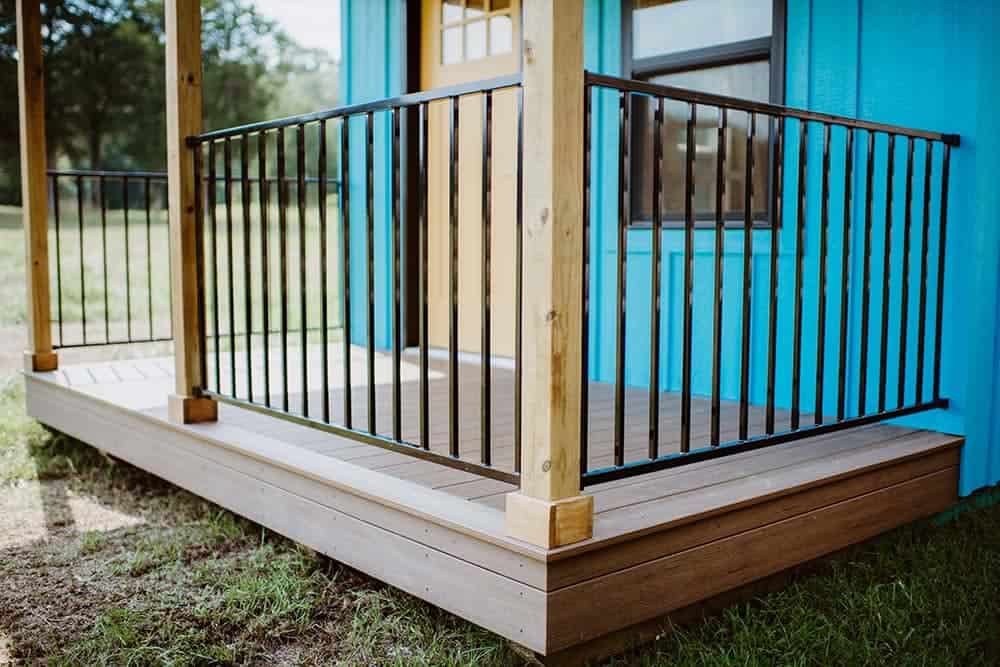 wood and metal accents on porch on blue prefab cabin