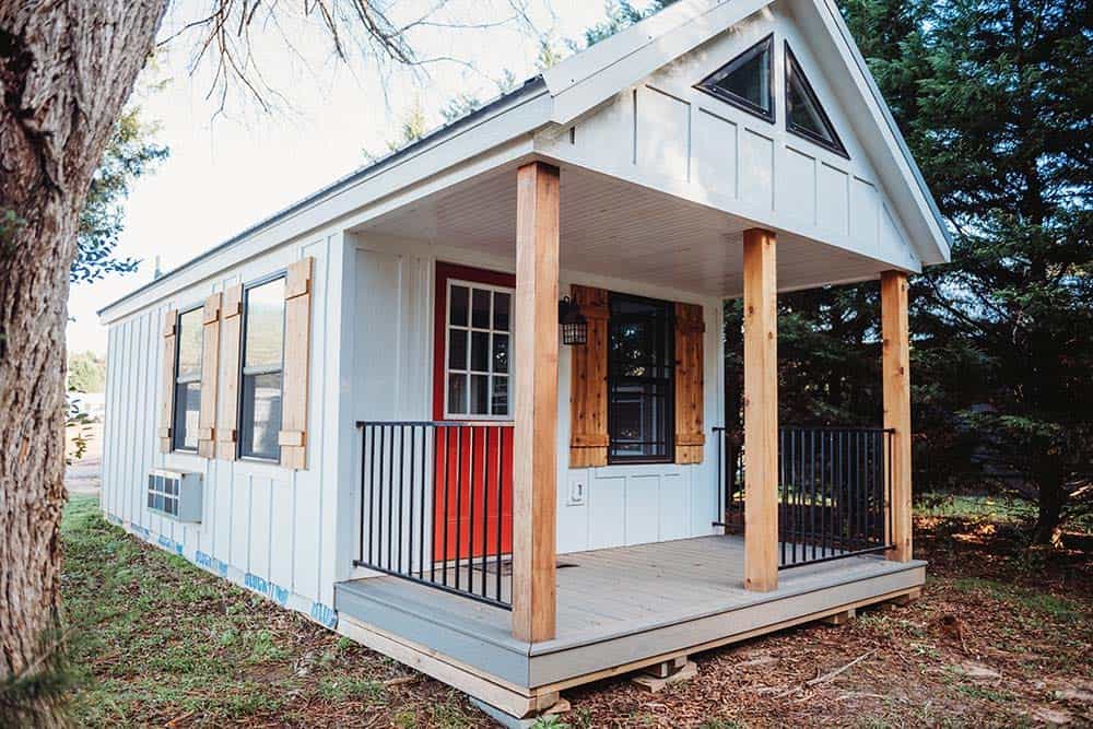 gray prefab cabin exterior with wood accents and covered porch