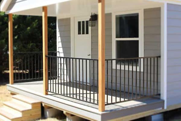 wood and metal accents on modern covered porch on modular tiny home